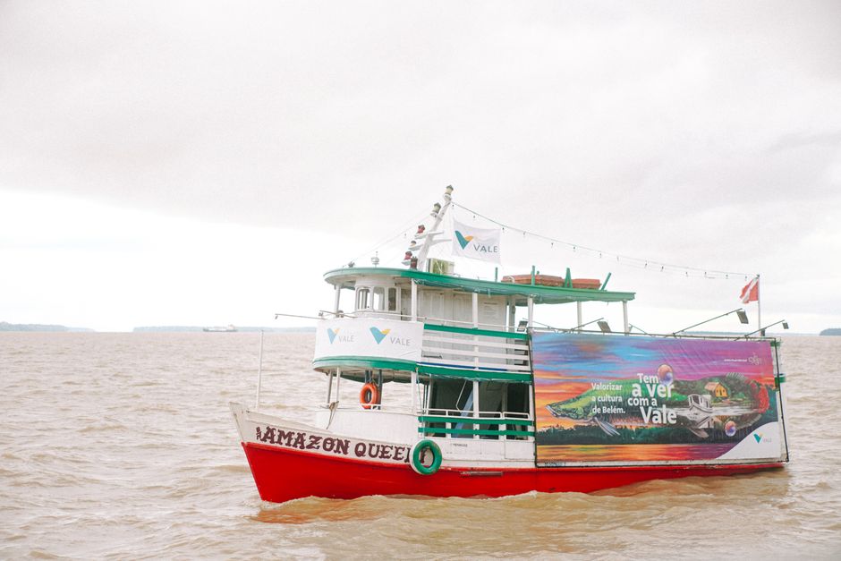 Cultura Brasileira — A colorful boat named Amazon Queen cruising on the Amazon River under a cloudy sky.